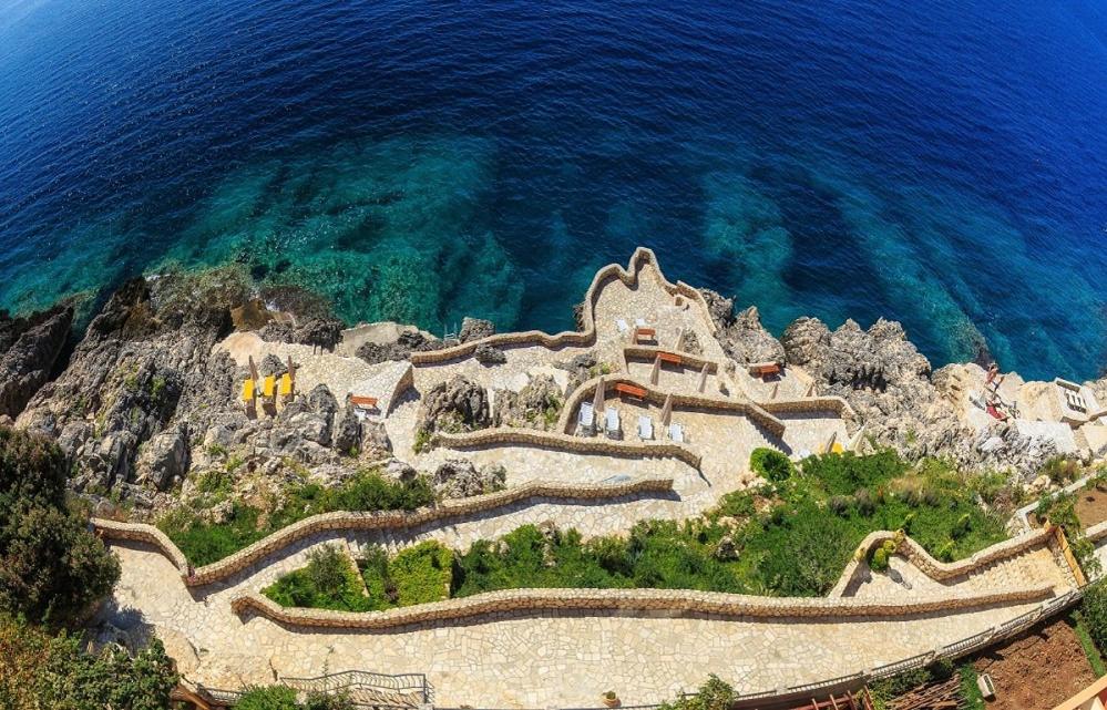 a group of stairs on a cliff near the water at Sveti Luka Apartments in Dobra Voda