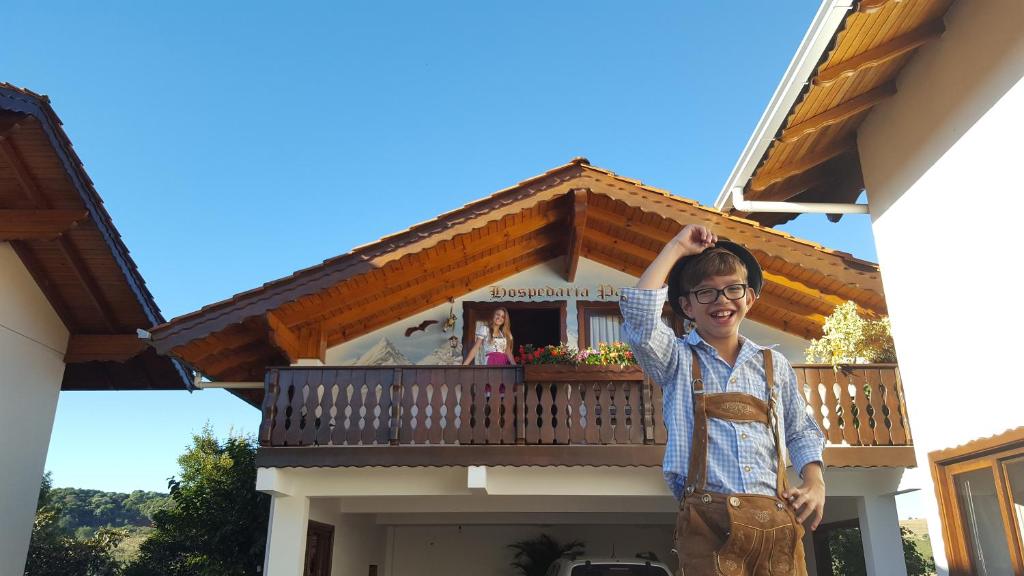 a man standing in front of a house at Pousada Pattis in Treze Tílias