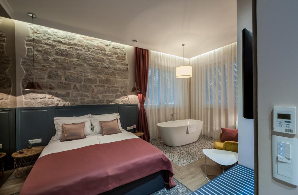 1 dormitorio con cama, bañera y bañera en Zadera Accommodation, en Zadar