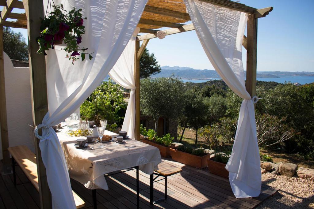 a table on a deck with a view of the ocean at B&B Bedda Ista in Porto Cervo