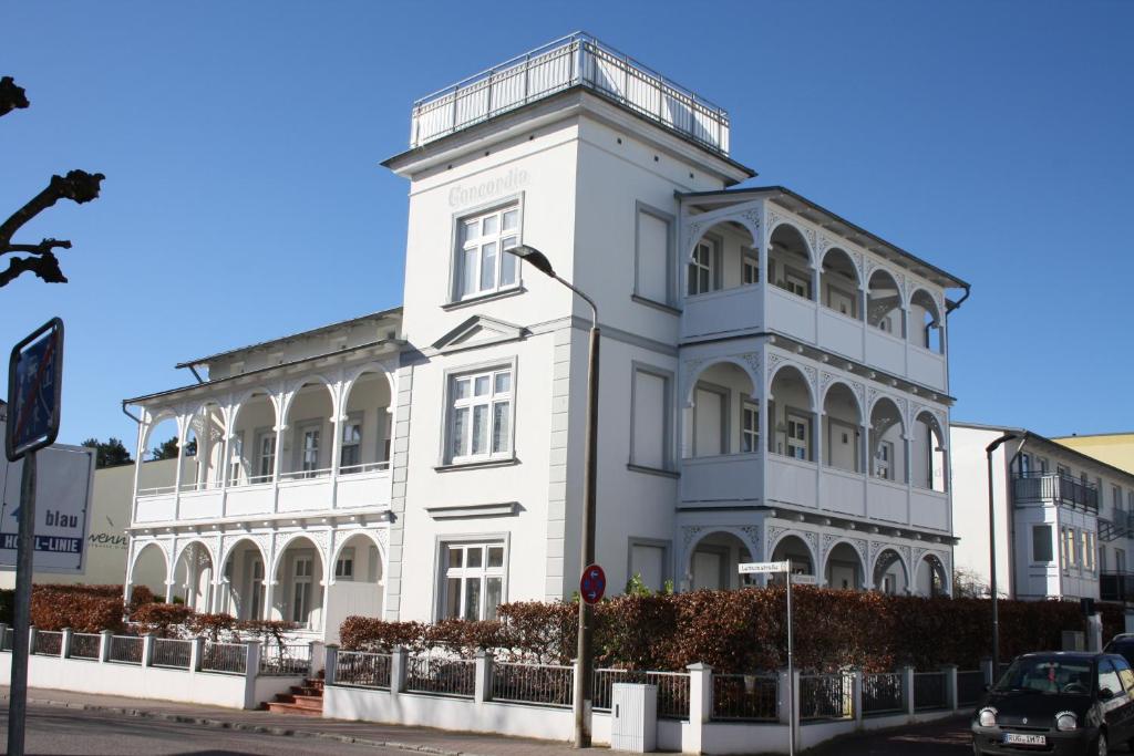 un bâtiment blanc au coin d'une rue dans l'établissement Villa Concordia Apartment Hiddensee, à Binz