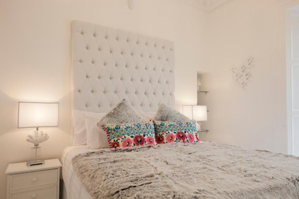 a white bedroom with a large bed with pillows at The Rooms at Bardons in Kilcullen