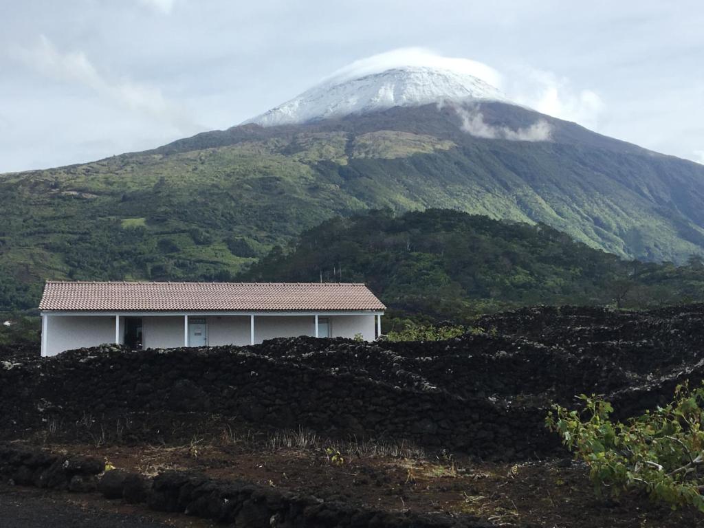 une maison en face d'une montagne enneigée dans l'établissement Insula Atlantis Apartments, à Madalena