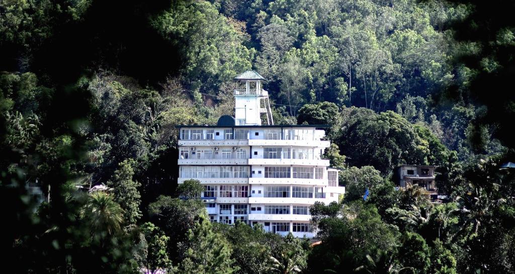 un edificio con una torre de reloj en la cima de una montaña en Auslink Hotel, en Amunumulla