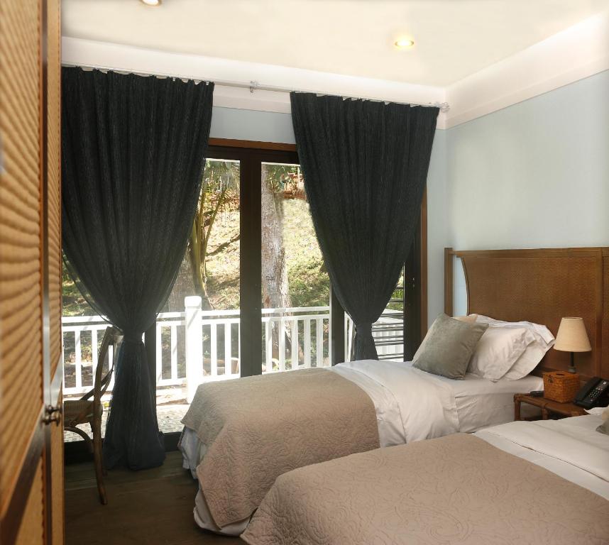 a hotel room with two beds and a balcony at Shell Villa apartel resort in Koror