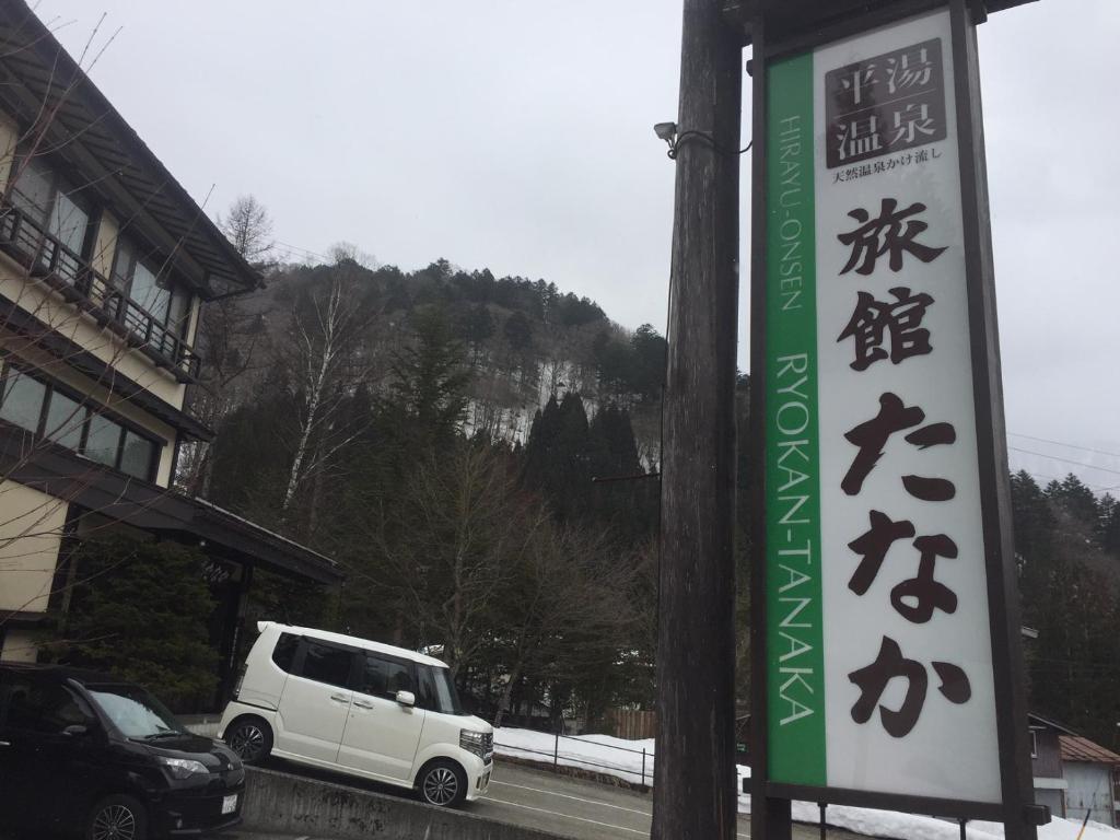 a white van parked on a street with a sign at Ryokan Tanaka in Takayama