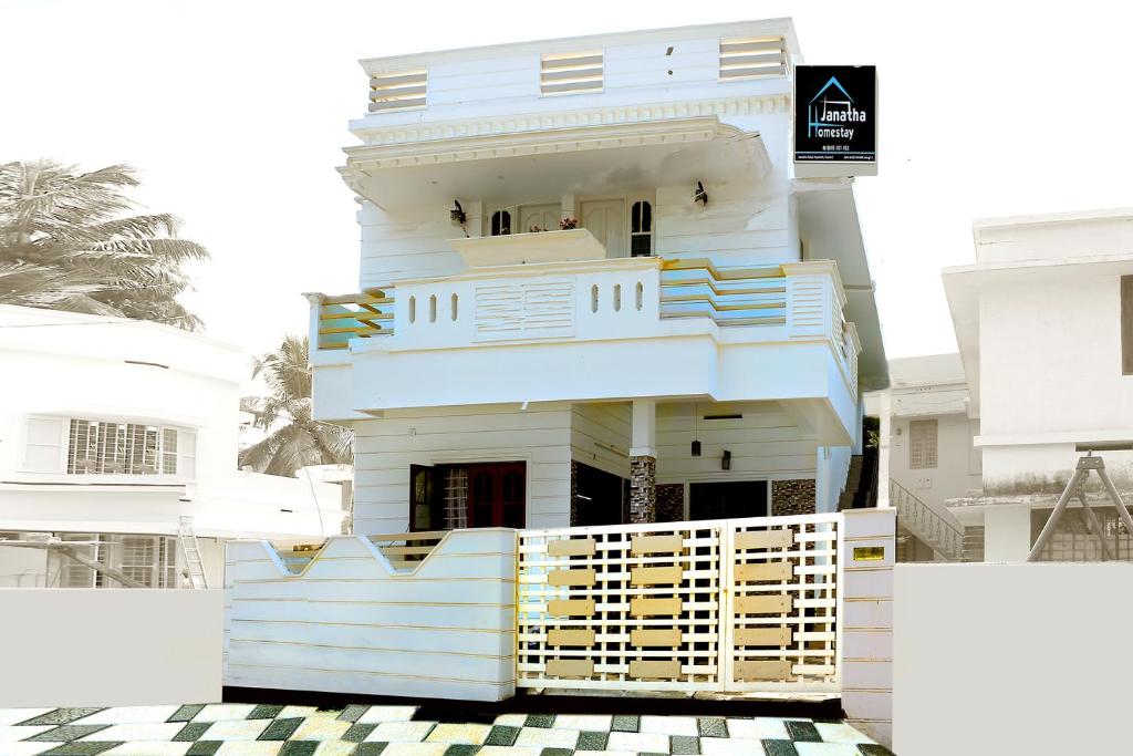 uma casa branca com escadas azuis e amarelas em Janatha Homestay em Cochin