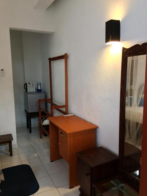 a bathroom with a mirror and a wooden dresser at Unawatuna Beach Bungalow - in Unawatuna