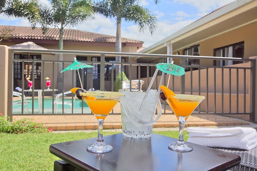 a table with two glasses of orange juice on it at Gecko Inn in Richards Bay