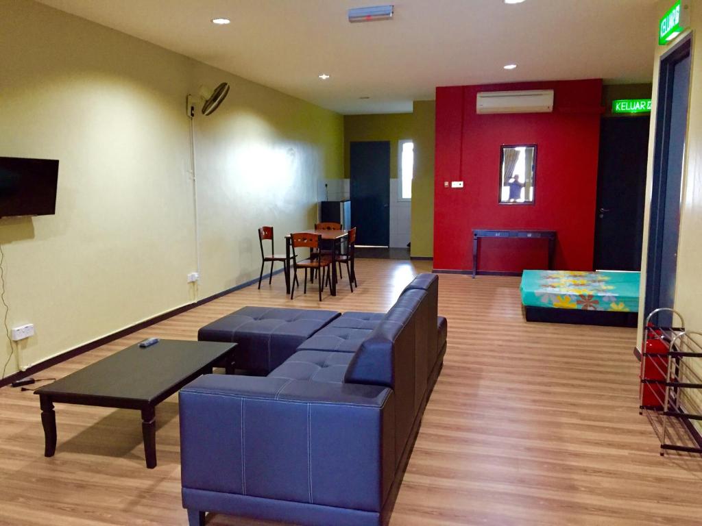 a living room with a blue couch and a table at SS Homestay Borneo Housing SL3 in Kuching