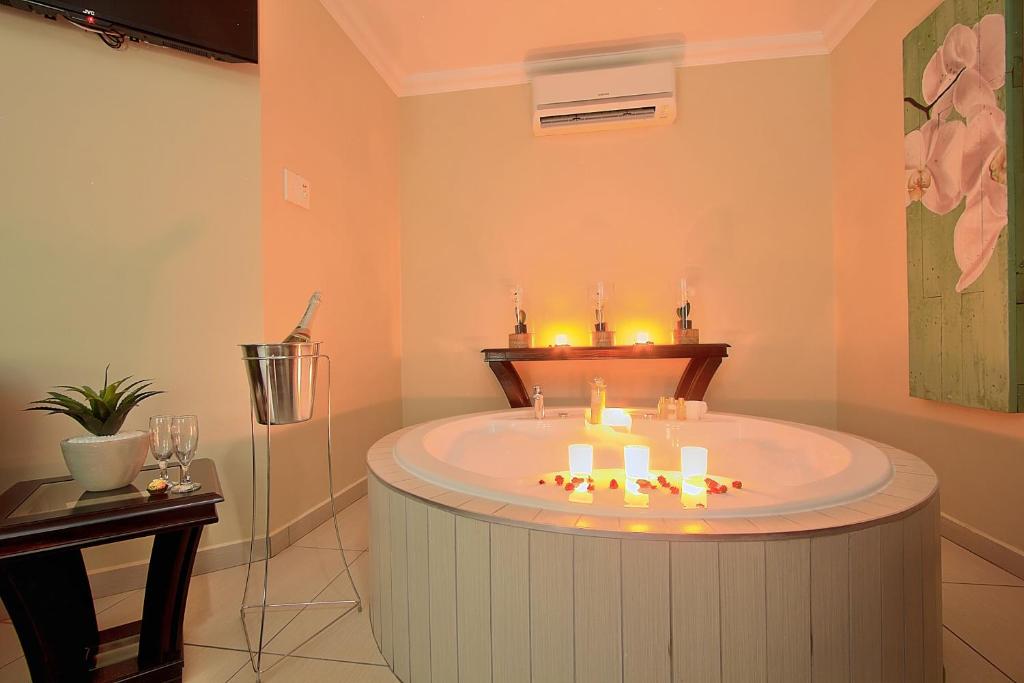 een badkamer met een rond bad met kaarsen bij Gecko Inn in Richards Bay