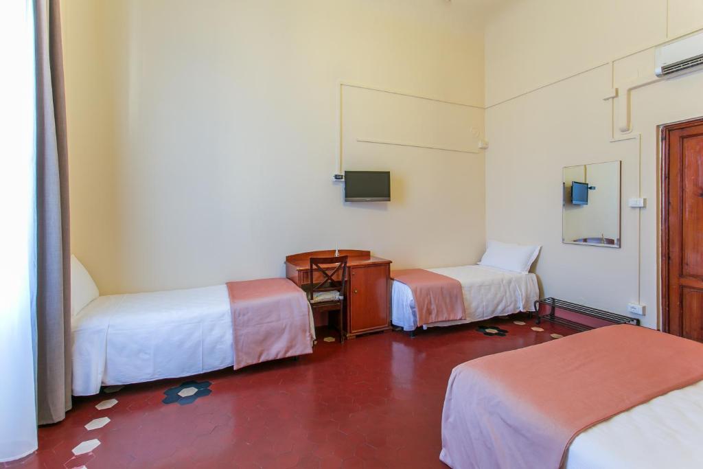 Postel nebo postele na pokoji v ubytování Hotel d'Azeglio Firenze
