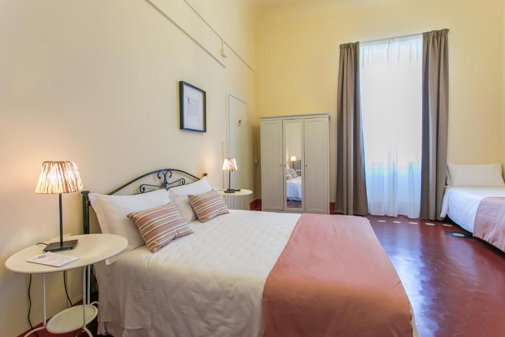 Postel nebo postele na pokoji v ubytování Hotel d'Azeglio Firenze