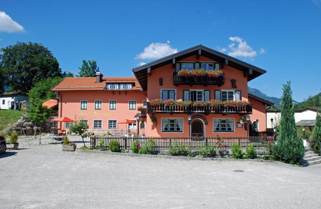 a house with flower boxes on the front of it at Hotel Garni Forsthaus Ruhpolding incl Chiemgau Karte in Ruhpolding