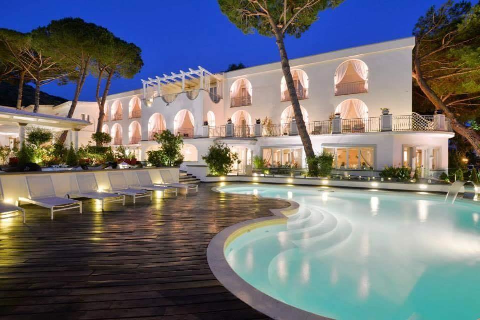 un hôtel avec une piscine ouverte la nuit dans l'établissement La Pineta Hotel Beach & Spa, à Acciaroli