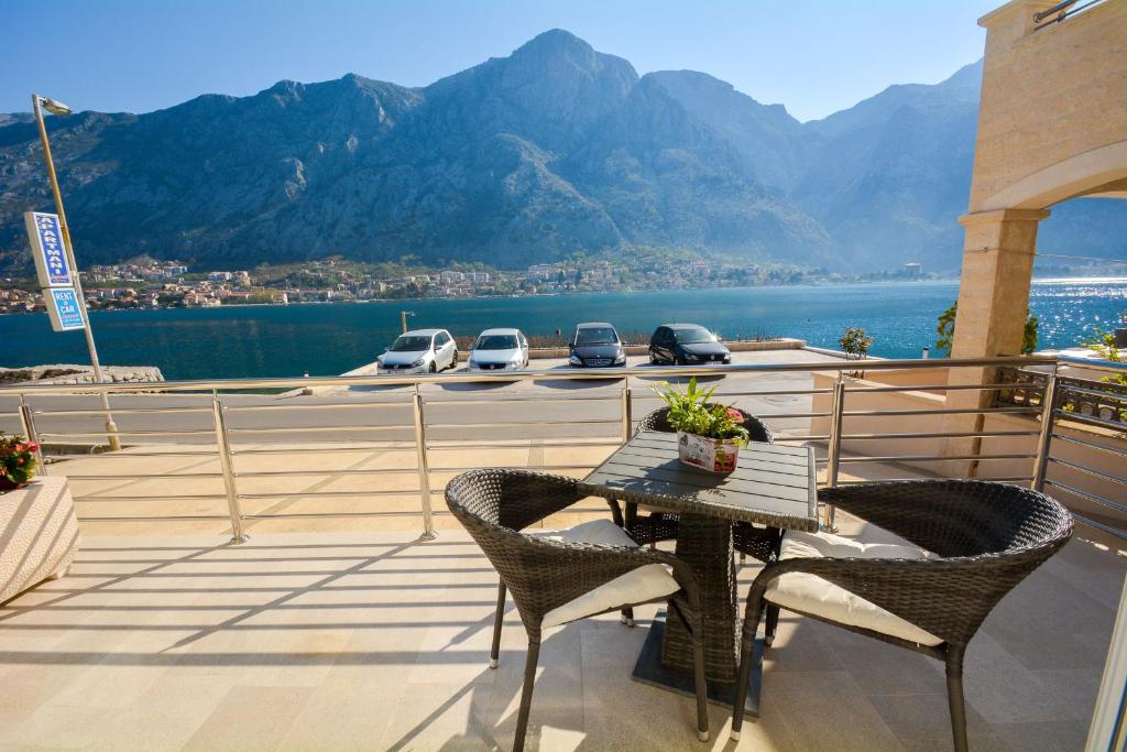 a table and chairs on a balcony with a view of the water at Apartments Jovanovic in Kotor