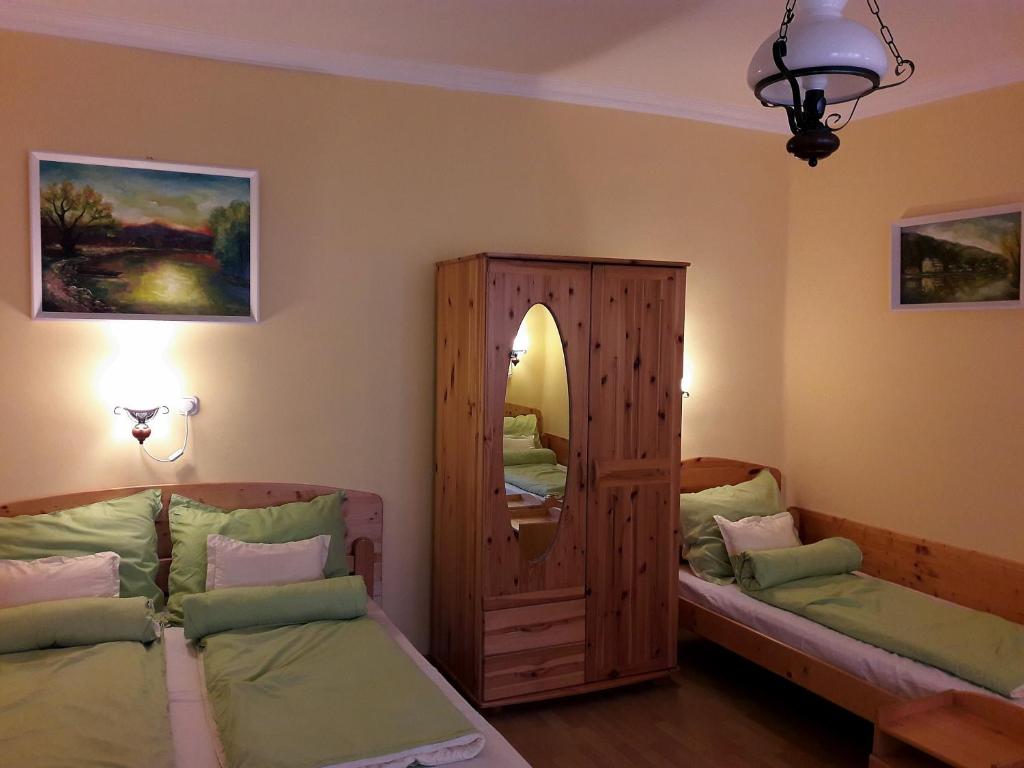 a bedroom with two twin beds and a mirror at Viktor Vendégház in Tokaj