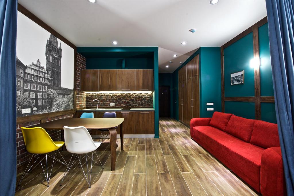 スヴェトロゴルスクにあるOld City Boutique Apartmentsのリビングルーム(赤いソファ、テーブル、椅子付)