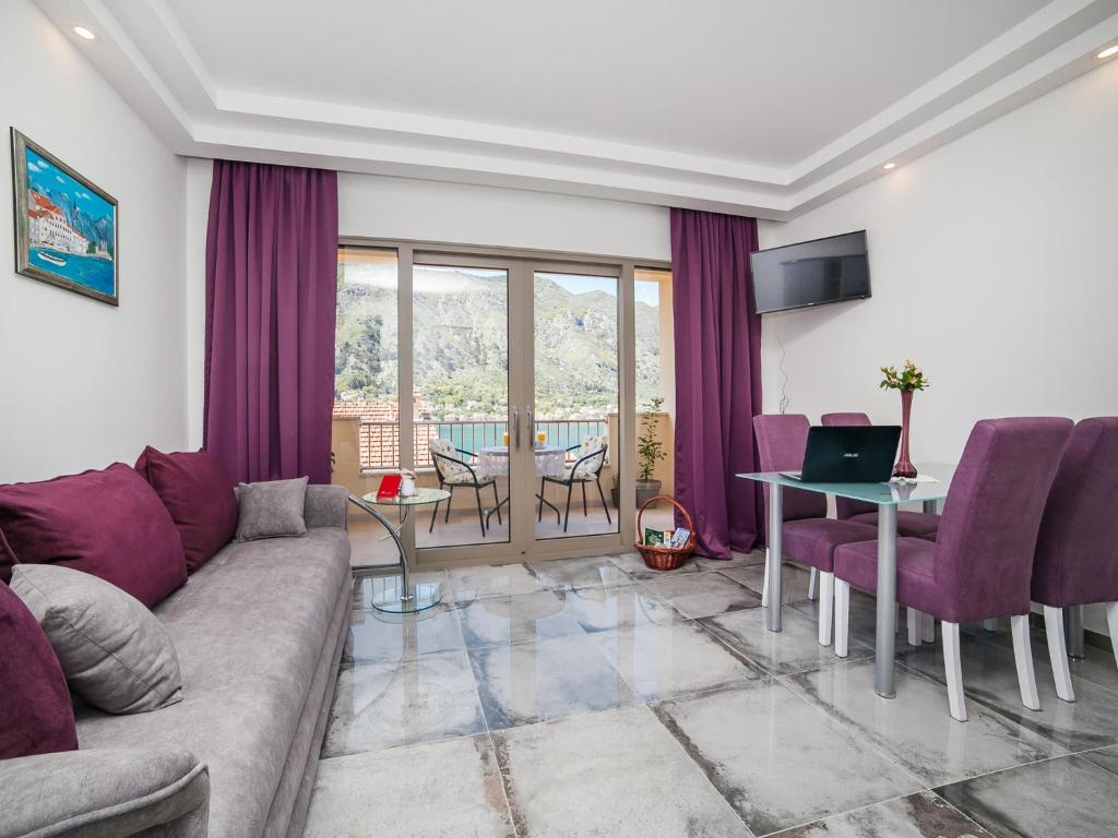 a living room with a couch and a table with a laptop at Apartments Castello in Kotor