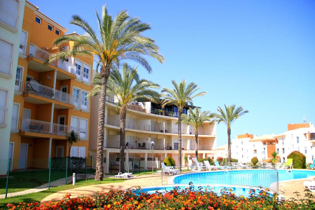 a view of a hotel with palm trees and a swimming pool at MSHomes Corcovada in Albufeira