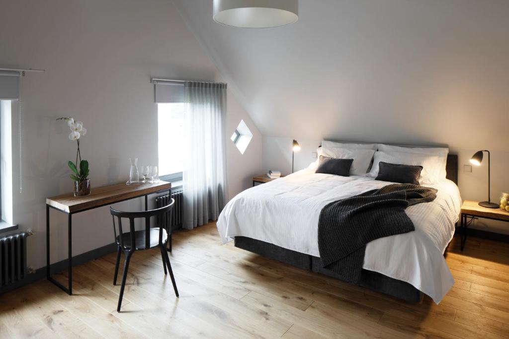 een slaapkamer met een bed en een bureau met een stoel bij Zoltners Hotel in Tērvete