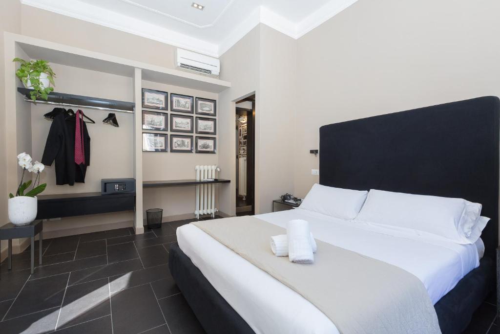 a bedroom with a large white bed with a black headboard at App Condotti Luxury Apartment In Rome in Rome