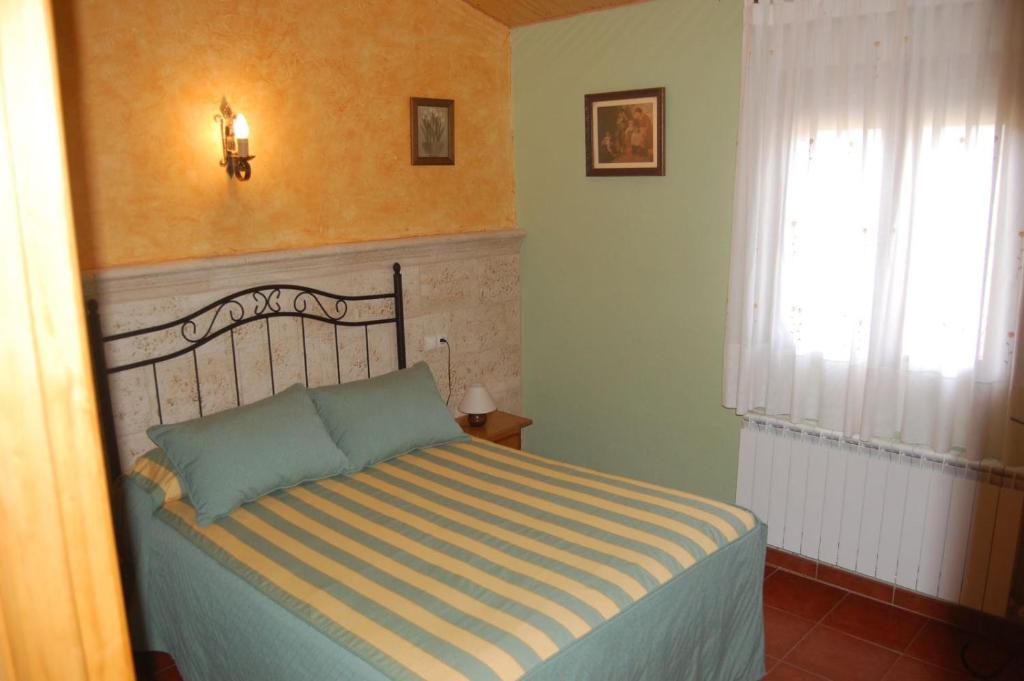 A bed or beds in a room at Gredos Casa Rural Los Treboles