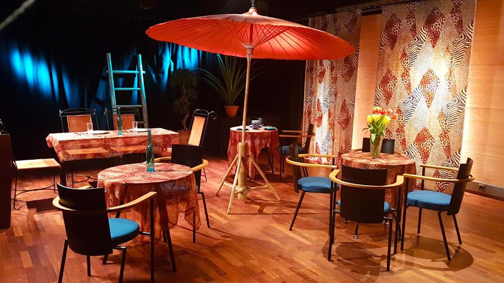 a room with tables and chairs and an umbrella at Theater and Beach Apartment in Tampere