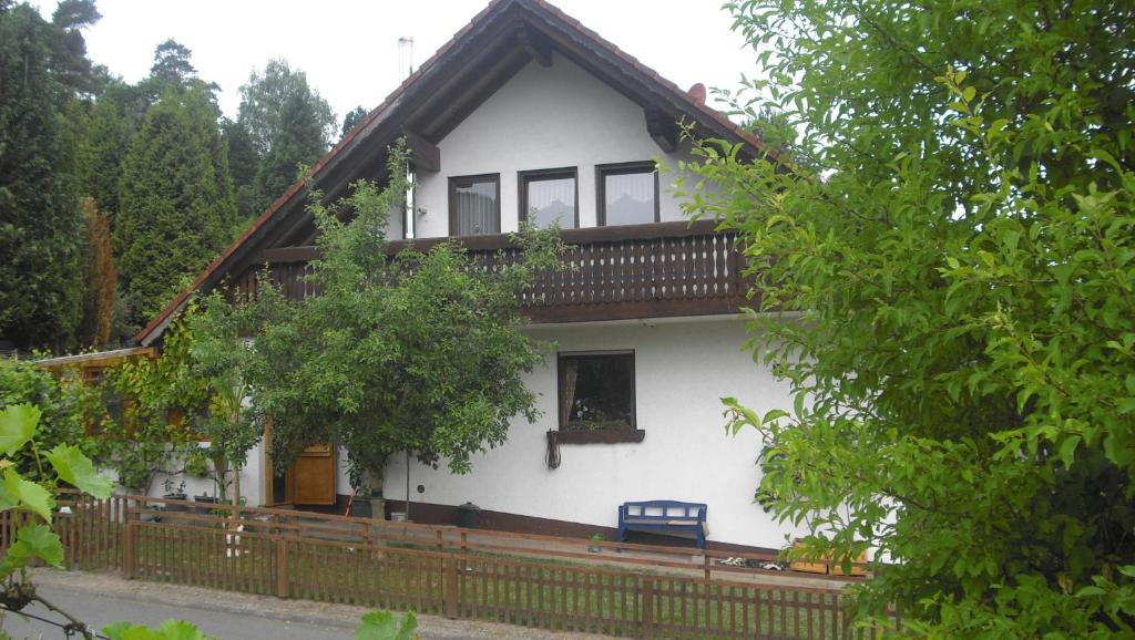 a white house with a wooden fence in front of it at Ferienwohnung Kuhn in Weilbach