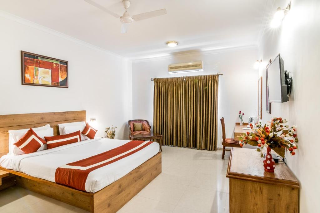 a hotel room with a bed and a tv at Octave Hotel - Double Road in Bangalore
