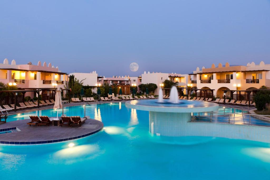 a large pool with chairs and fountains in a resort at Gaia Palace in Mastichari