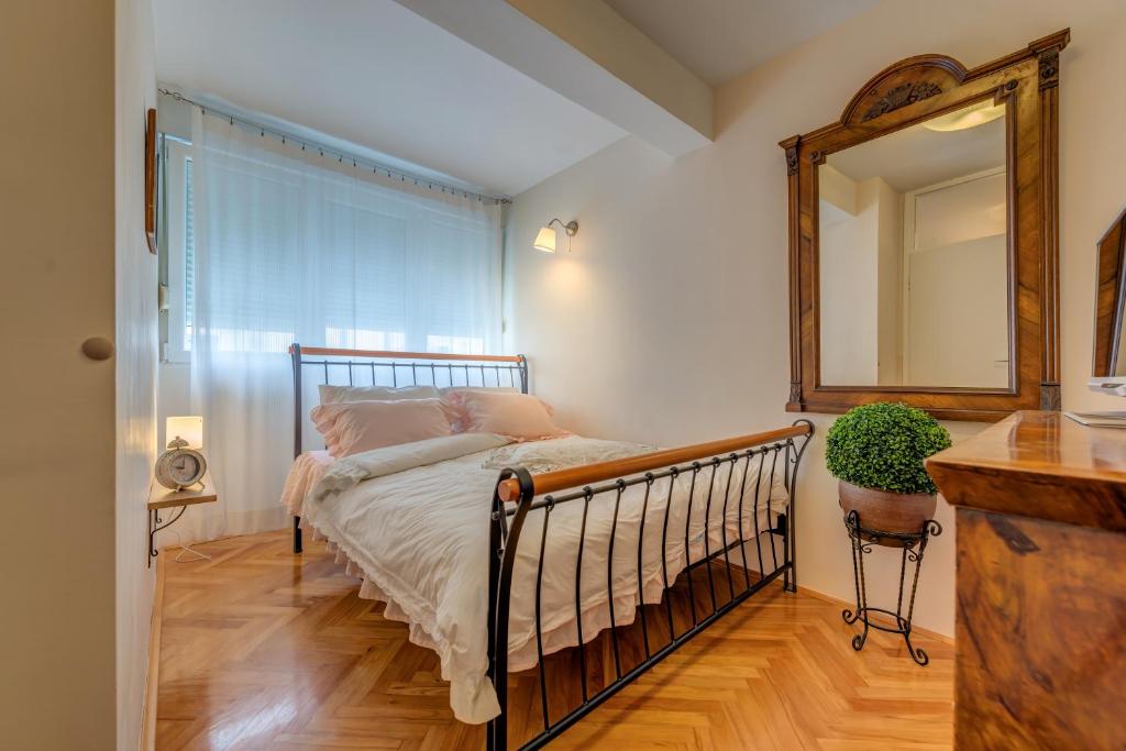 a bedroom with a bed and a mirror at Apartments Zoran in Split