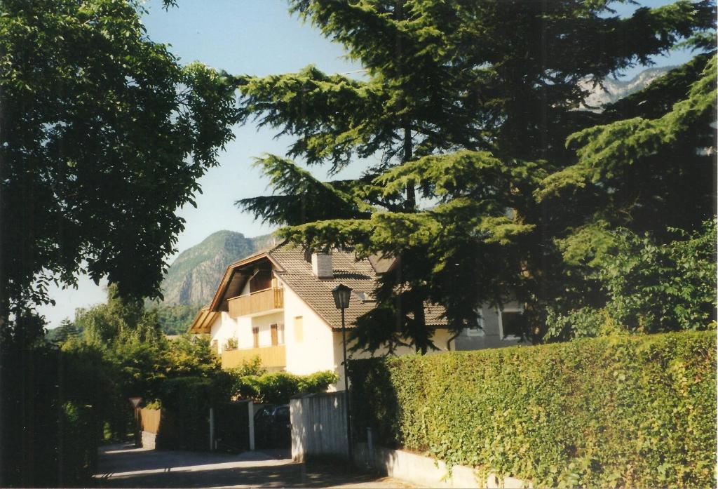 a house with a hedge in front of a building at Ferienwohnungen Reiterer in Appiano sulla Strada del Vino