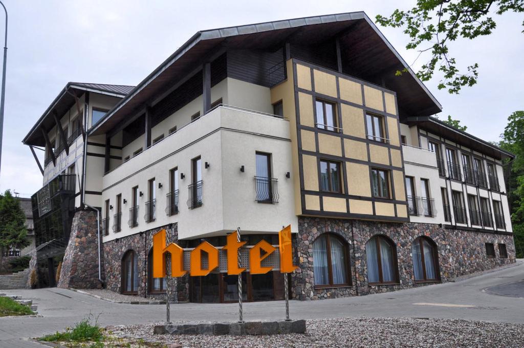 a building with a nido sign in front of it at Hotel Pod Kluką in Słupsk