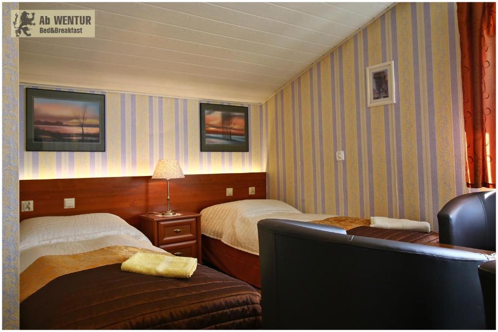 a hotel room with two beds and a couch at AbWentur Pokoje in Gdańsk