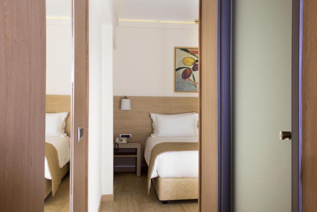Postel nebo postele na pokoji v ubytování Golden Age Athens Hotel