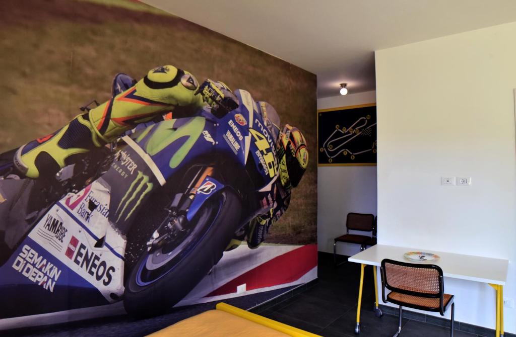 een kamer met een schilderij van een motorfiets aan de muur bij Rental rooms Antonella in Tavullia