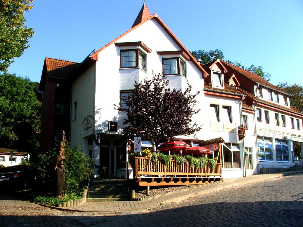 um edifício branco com um banco à frente em Hotel Am Markt em Sagard