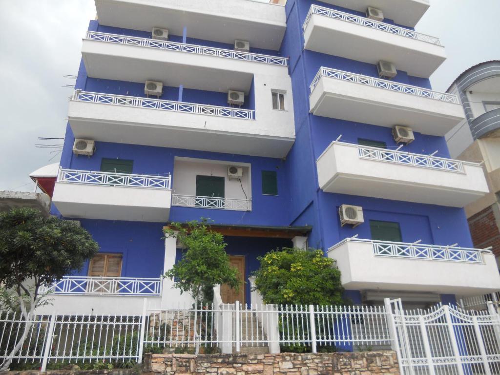 un edificio azul con balcones blancos y una valla en Hotel Soan, en Sarandë