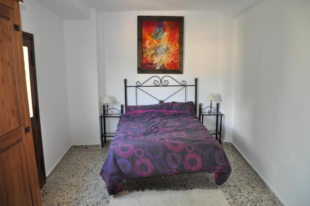 オルヒバにあるCasa Tamayoの紫色の掛け布団付きのベッド1台