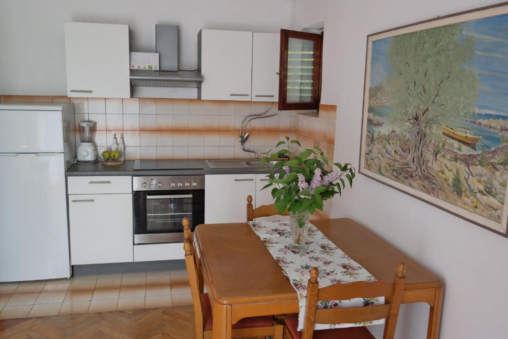 una cocina con una mesa con un jarrón de flores. en Apartment Lavanda, en Zadar