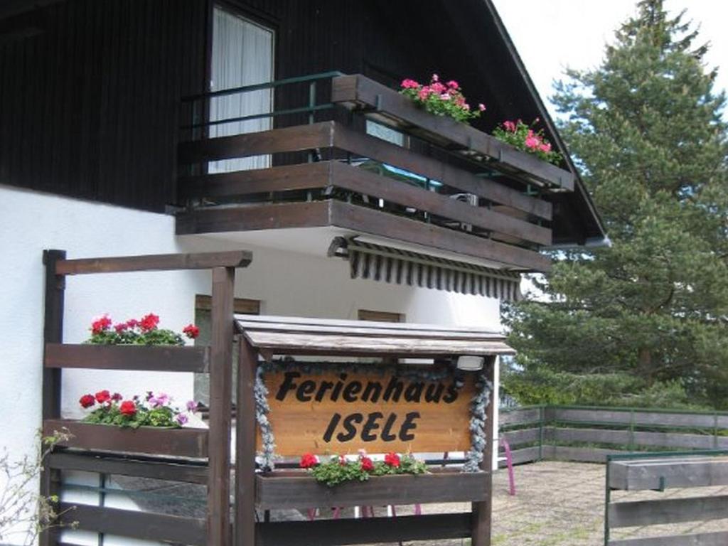 un cartello di fronte a un edificio con dei fiori sopra di Ferienhaus Isele a Feldberg