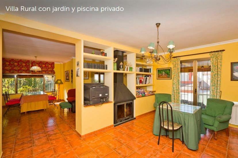 een woonkamer met een tafel en een open haard bij Villa Loma Linda in Ogíjares