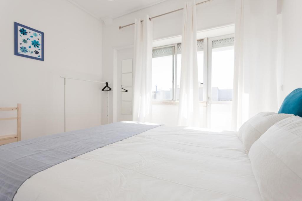 リスボンにあるFLH Marques Modern Flatの白いベッドルーム(窓付きの白いベッド付)