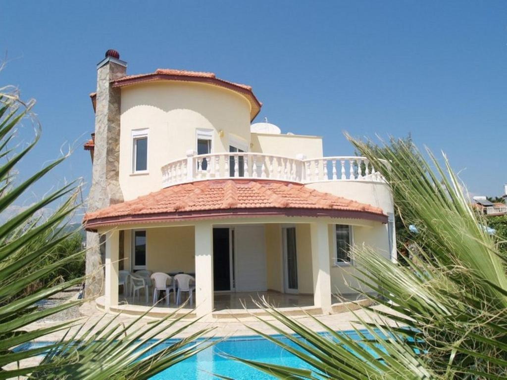 a villa with a swimming pool in front of a house at Villa Mutlu in Avsallar