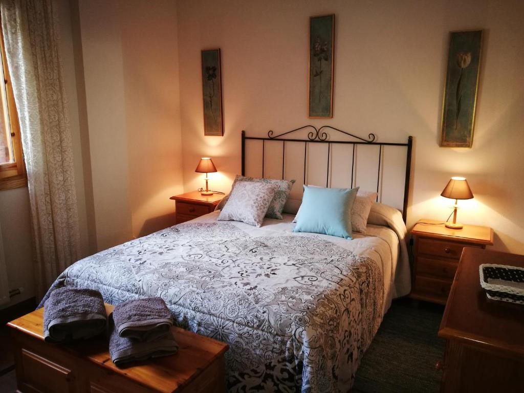 a bedroom with a large bed with two lamps at El Mirador de Ordesa in Torla-Ordesa