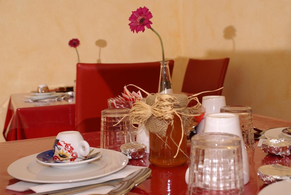 una mesa con un jarrón con una flor dentro en Sa Mamma e Sole B&B, en Cala Gonone