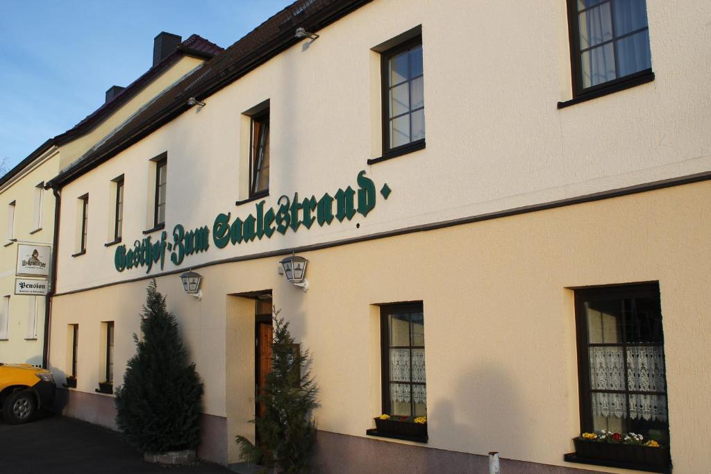 ein Gebäude mit einem Schild an der Seite in der Unterkunft Gasthof & Pension Zum Saalestrand in Bad Dürrenberg