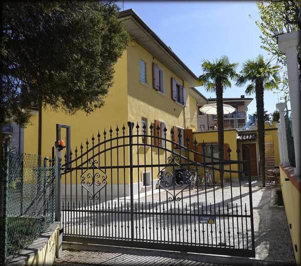 um edifício amarelo com um portão em frente em Relais Sweet Days em Peschiera del Garda