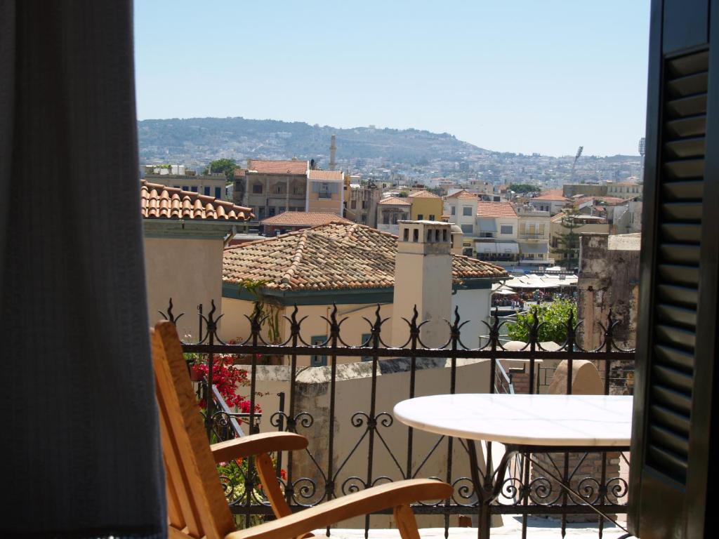 a balcony with a table and chairs and a view of a city at Silde Studios & Apartments in Chania